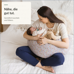 Mutter mit Baby auf dem grauen C-förmigen Still- und Seitenschläferkissen