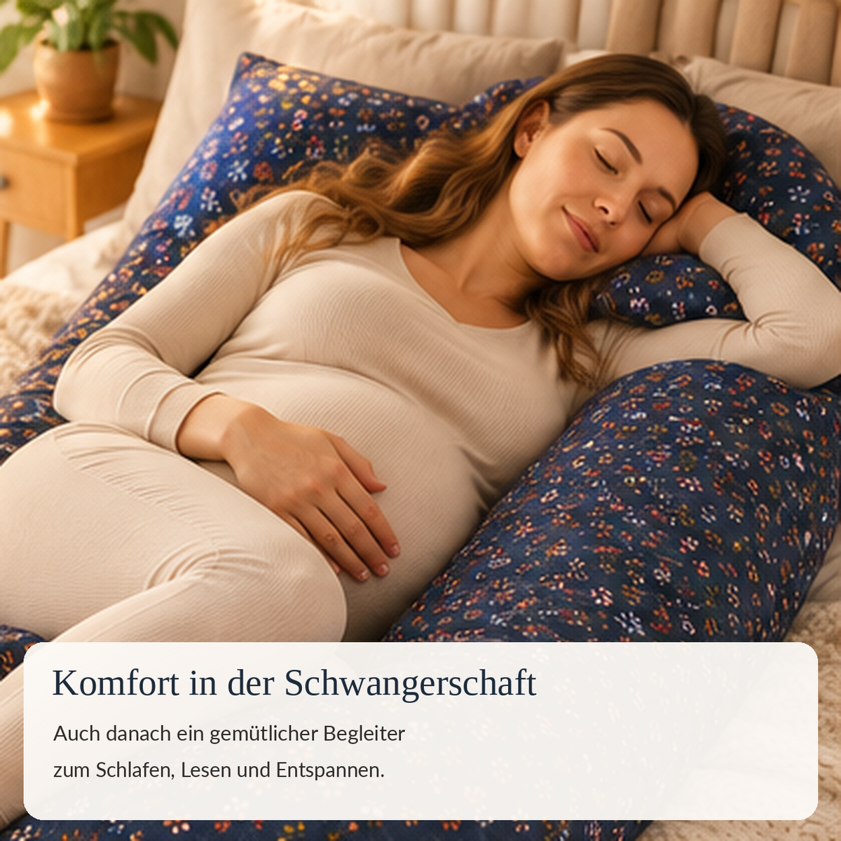 Schwangere Frau entspannt im U-förmigen Kissen mit dunkelblauem Blumenbezug